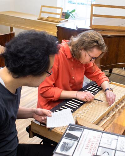 Mike Lee, Ph.D. ’15 and Elizaveta Zabelina ’24 regulate a piano modeled after that of Johann Schantz (1800) by Thomas and Barbara Wolf, 1991.